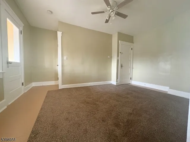 a view of a big room with windows and chandelier fan