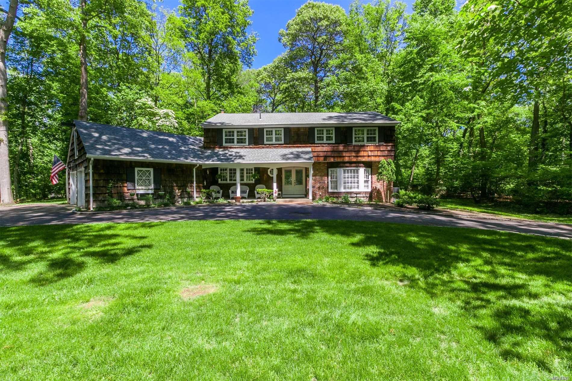 21 Wilderness Road Nissequogue, NY 11780 - Photo 1 of 1 a front view of a house with a yard table and chairs