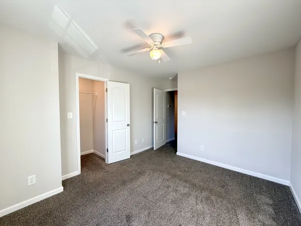 an empty room with a ceiling fan and a window