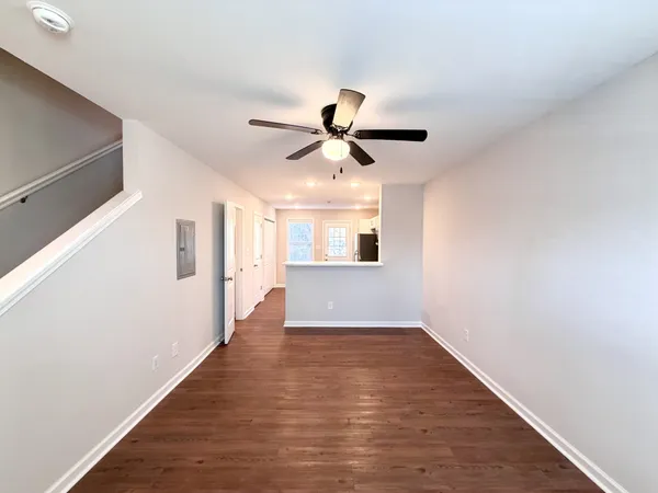 a view of an empty room with window and wooden floor