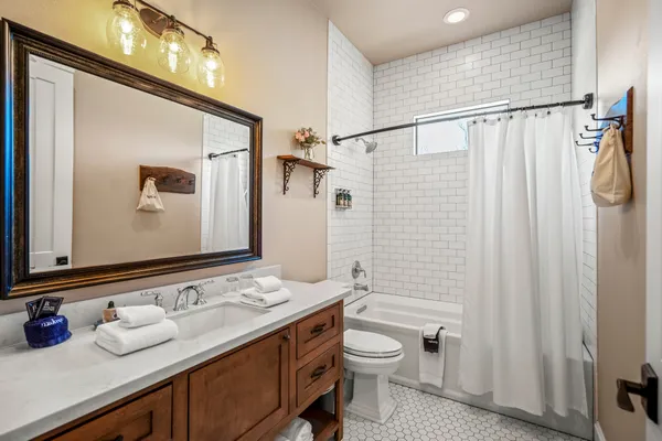 a bathroom with a granite countertop sink toilet and shower