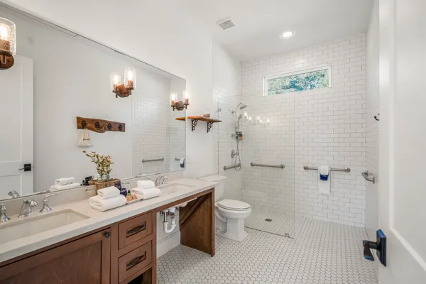 a bathroom with a double vanity sink toilet and shower