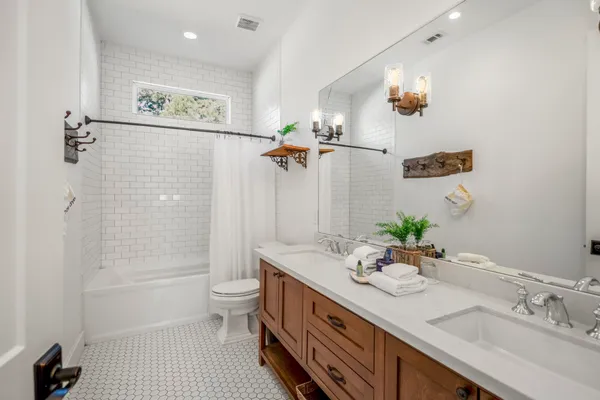 a bathroom with a double vanity sink toilet and shower