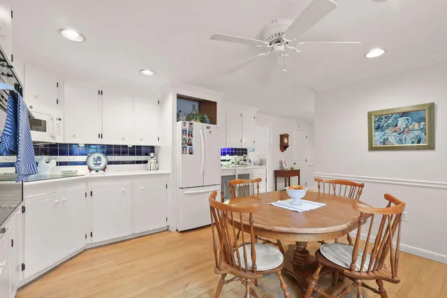 a view of a dining room with furniture a chandelier and wooden floor