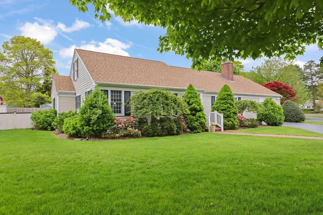 a view of a house with a big yard and potted plants