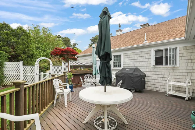 a view of a chair and tables in the patio along the house