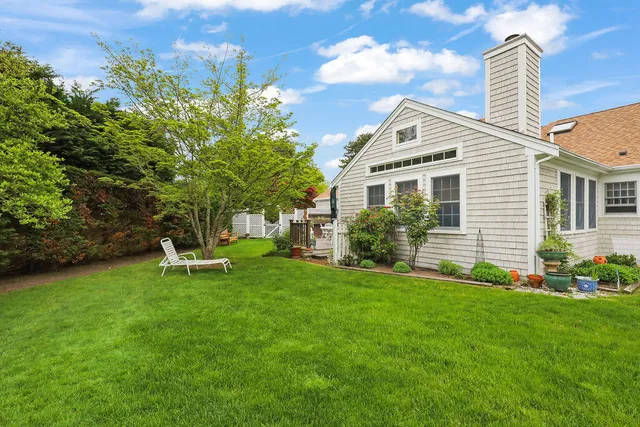 a view of a house with backyard and a tree
