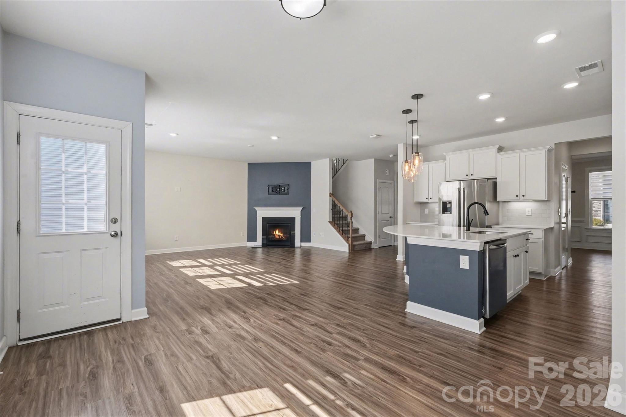 14510 Grundys Way Davidson, NC 28036 - Photo 14 of 43 a large kitchen with kitchen island a sink wooden floor and stainless steel appliances