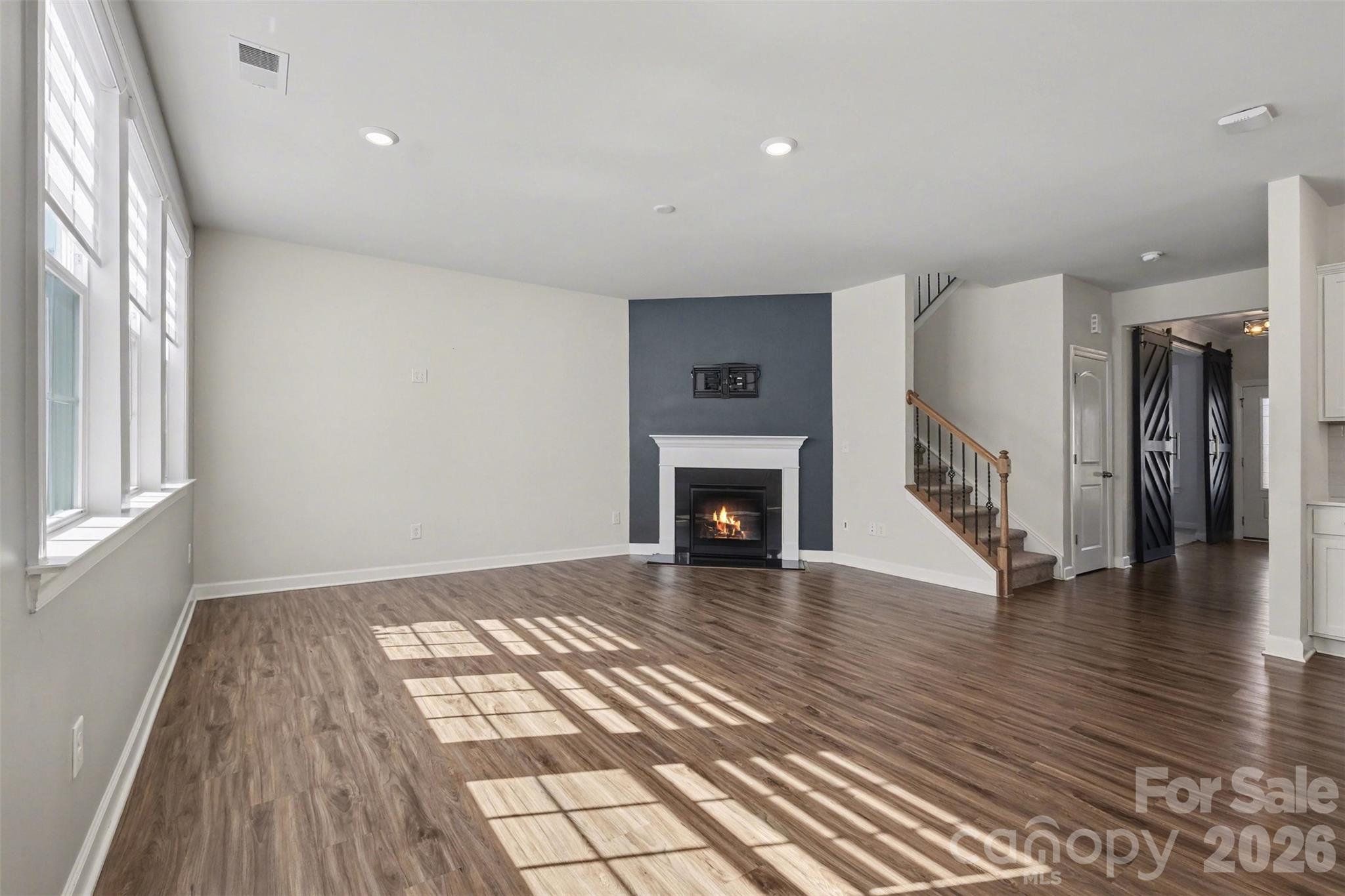 14510 Grundys Way Davidson, NC 28036 - Photo 16 of 43 a view of empty room with wooden floor and fireplace