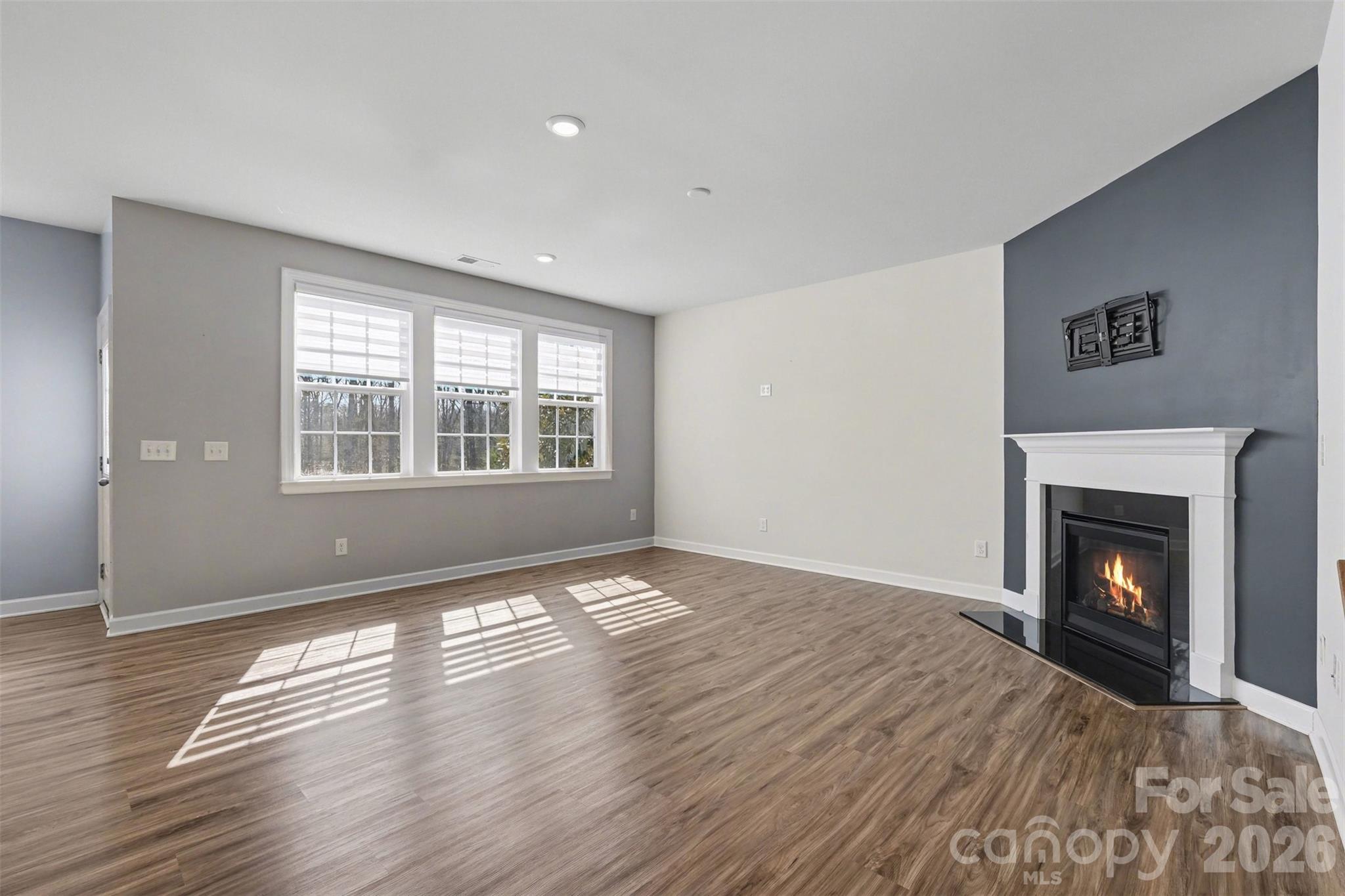14510 Grundys Way Davidson, NC 28036 - Photo 17 of 43 a view of an empty room with wooden floor fireplace and a window