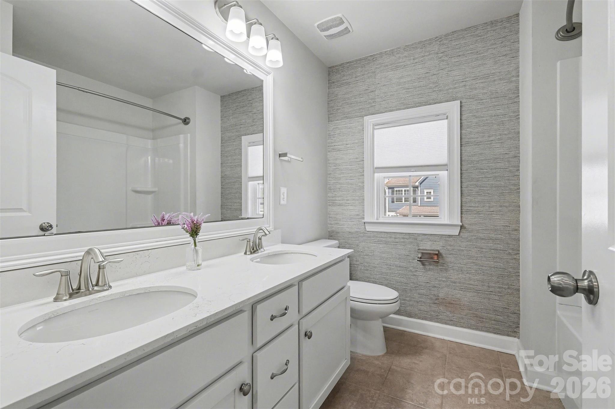 14510 Grundys Way Davidson, NC 28036 - Photo 27 of 43 a bathroom with a double vanity sink toilet and a mirror