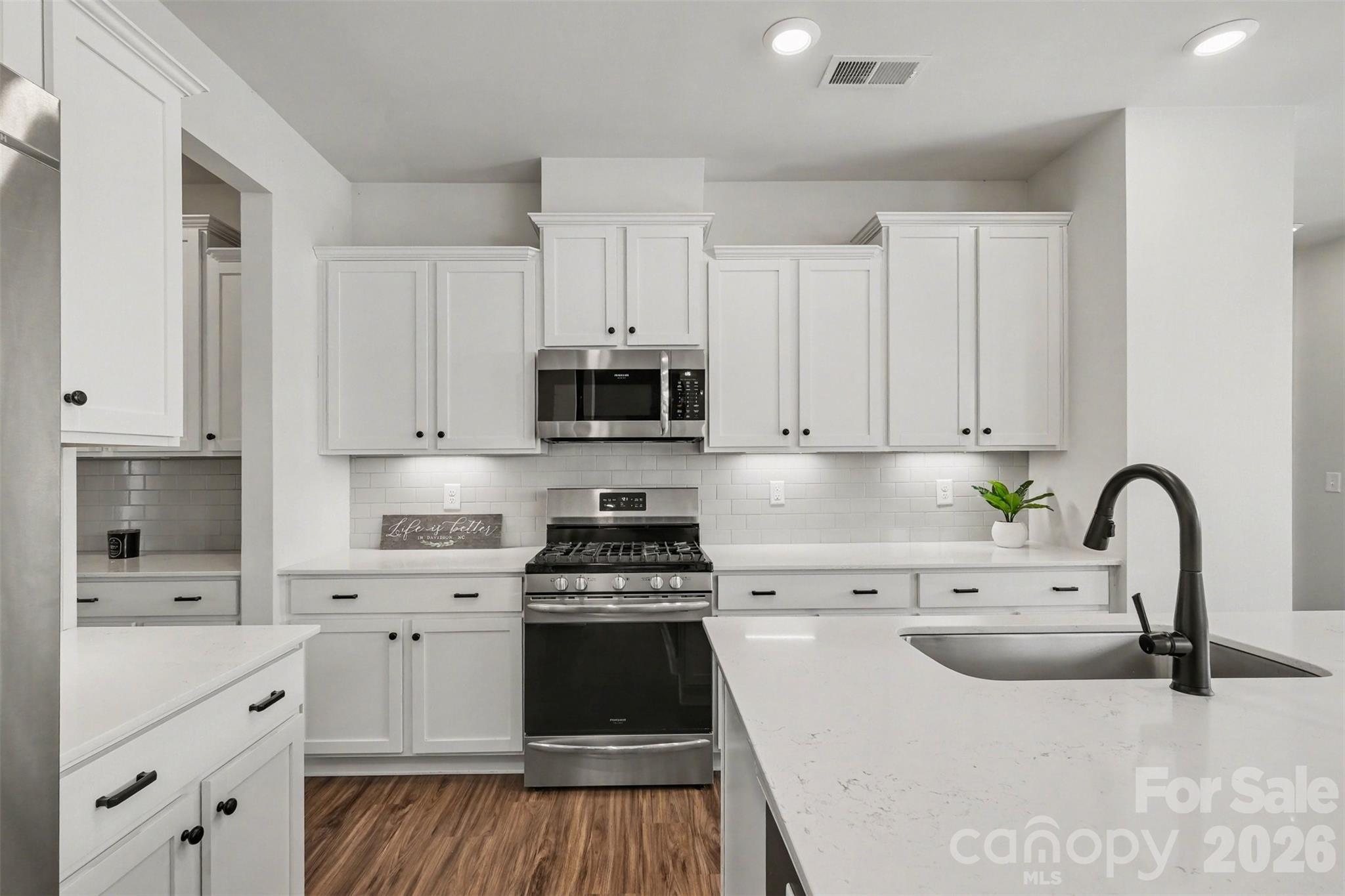 14510 Grundys Way Davidson, NC 28036 - Photo 10 of 43 a kitchen with white cabinets a sink and appliances