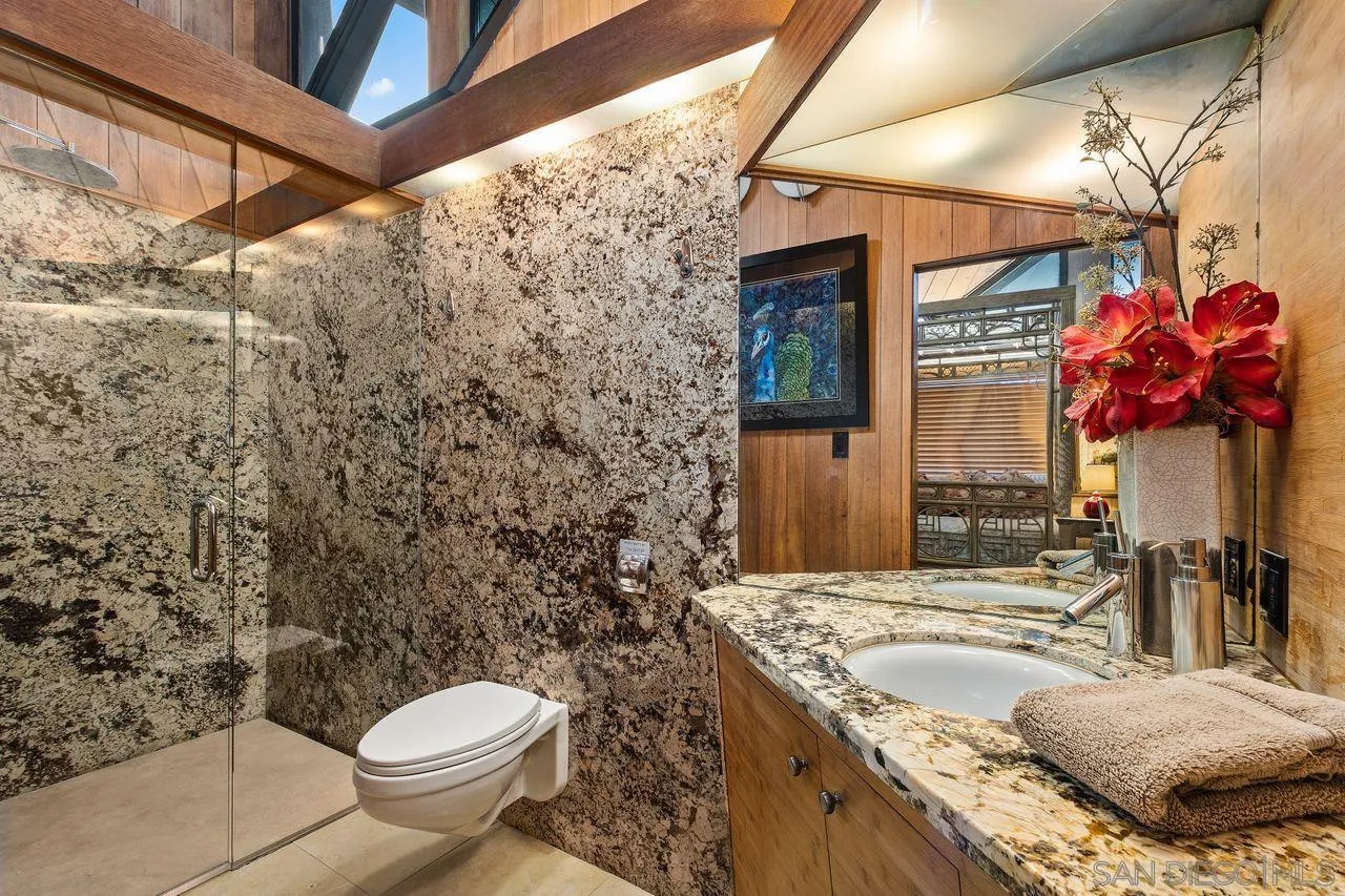 2694 Bayside Walk San Diego, CA 92109 - Photo 31 of 37 a bathroom with a granite countertop sink a toilet and mirror