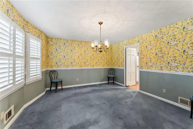 a view of an empty room with window and furniture