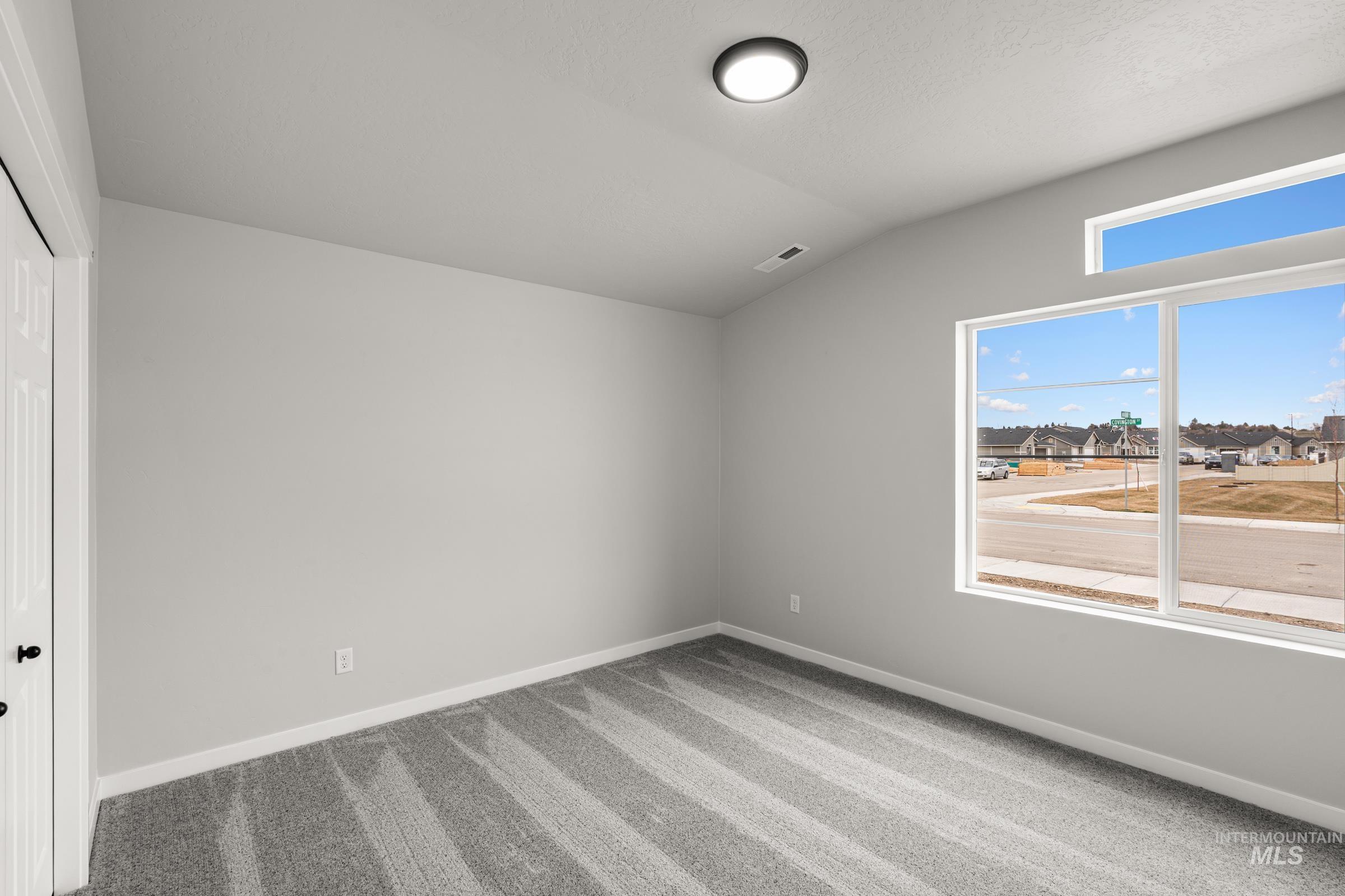1449 Covington Street Middleton, ID 83644 - Photo 13 of 21 Unfurnished bedroom with lofted ceiling, a closet, light colored carpet, and a residential view