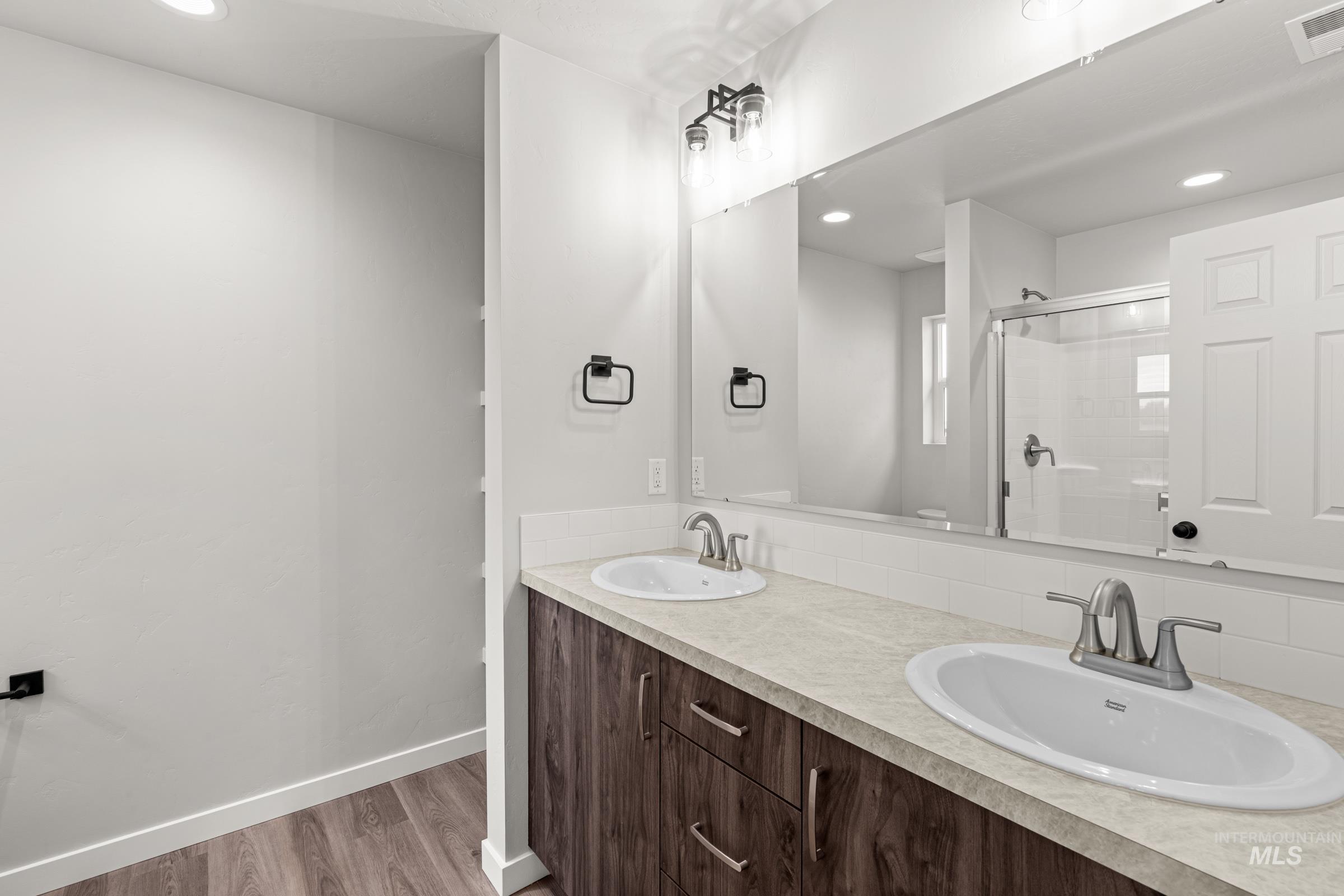 1449 Covington Street Middleton, ID 83644 - Photo 18 of 21 Full bathroom featuring double vanity, a shower stall, recessed lighting, and light wood-style flooring