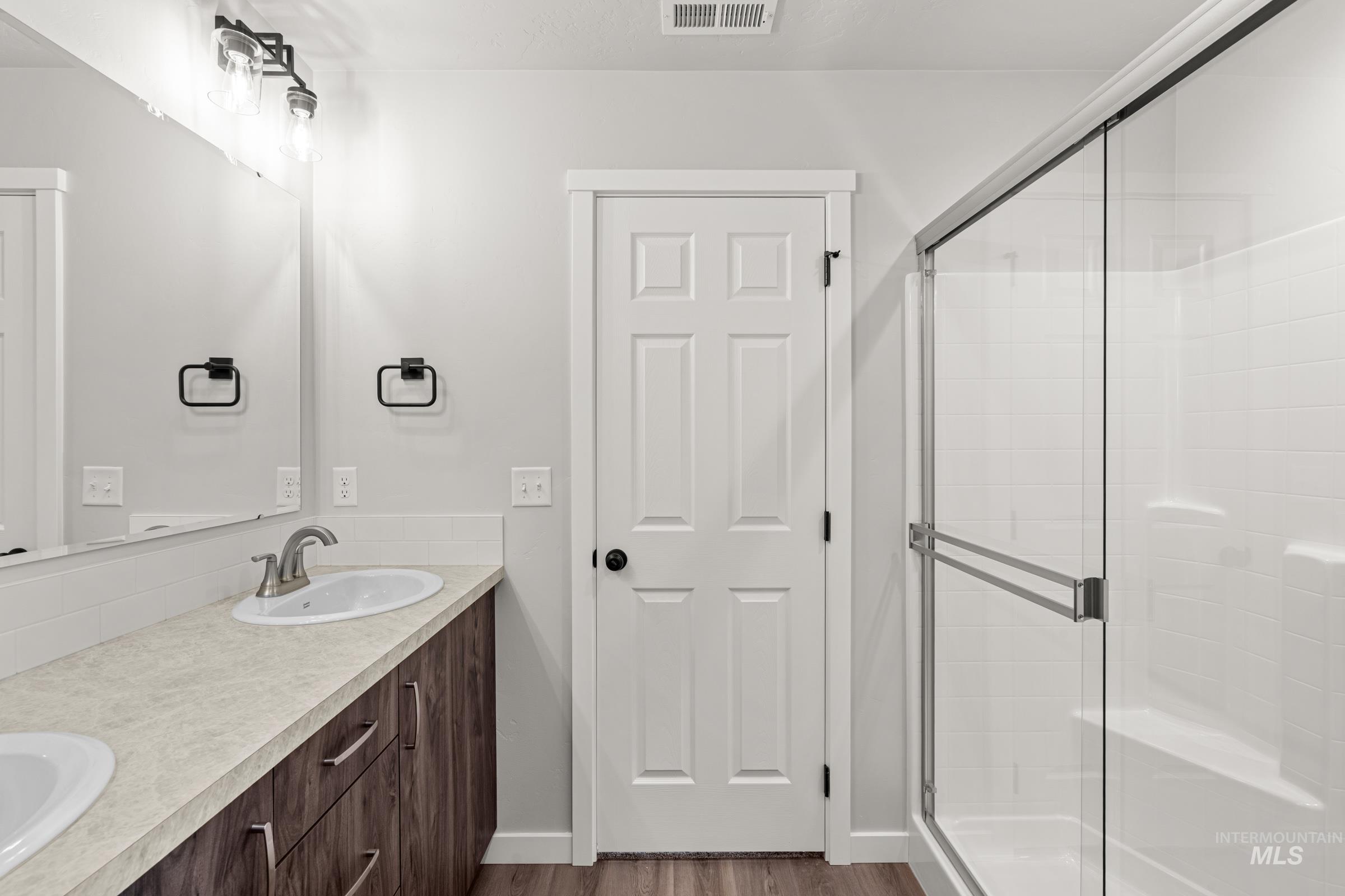 1449 Covington Street Middleton, ID 83644 - Photo 20 of 21 Bathroom featuring a stall shower, double vanity, and dark wood-type flooring