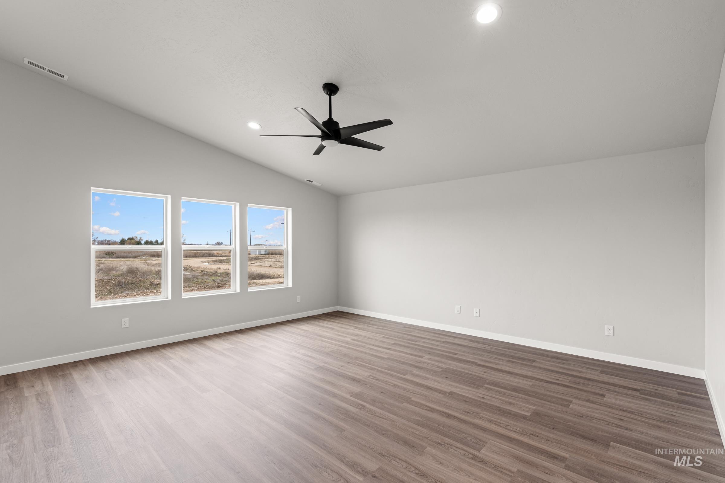 1449 Covington Street Middleton, ID 83644 - Photo 7 of 21 Empty room featuring lofted ceiling, a ceiling fan, dark wood-style floors, and recessed lighting