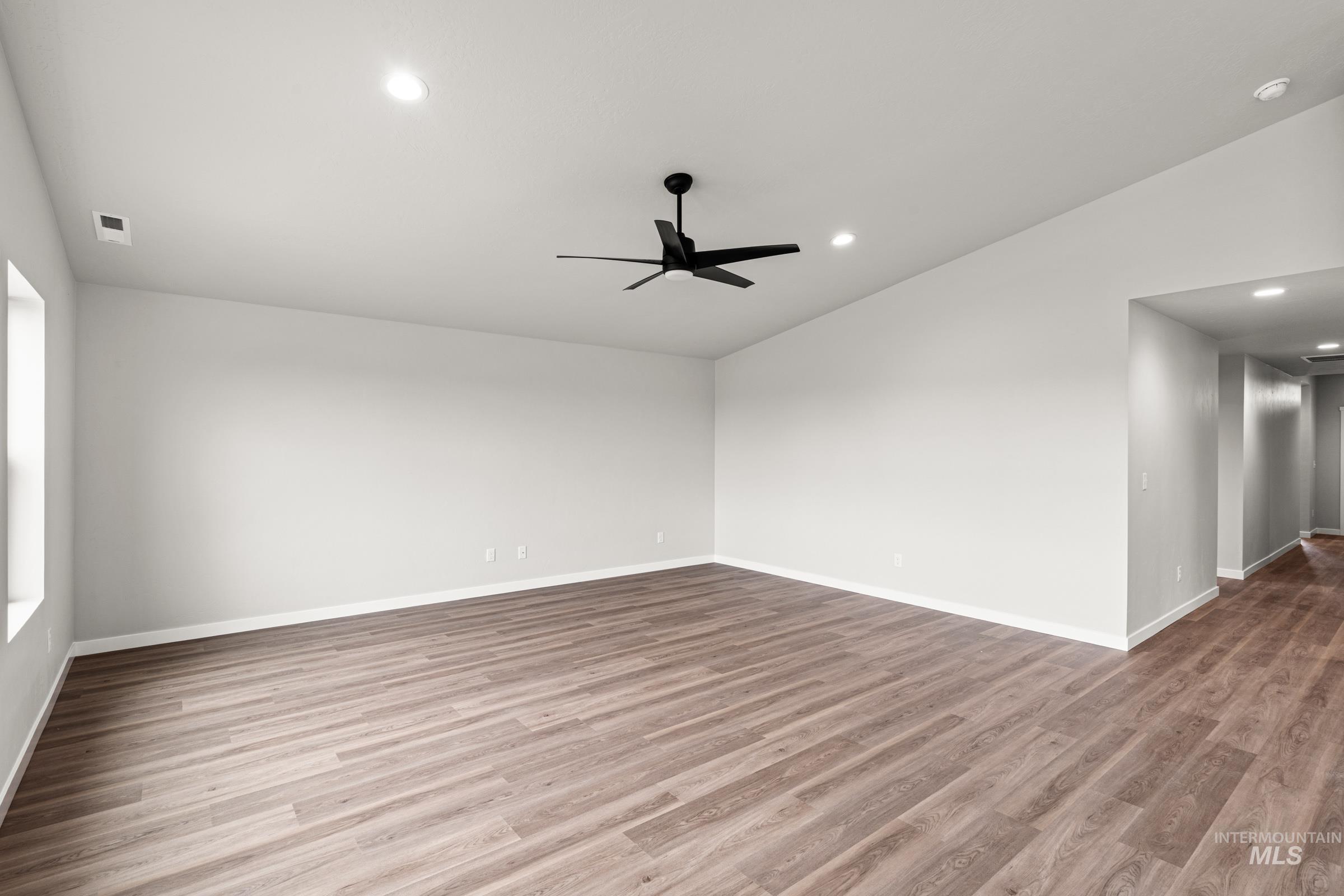 1449 Covington Street Middleton, ID 83644 - Photo 8 of 21 Empty room with vaulted ceiling, ceiling fan, wood finished floors, and recessed lighting