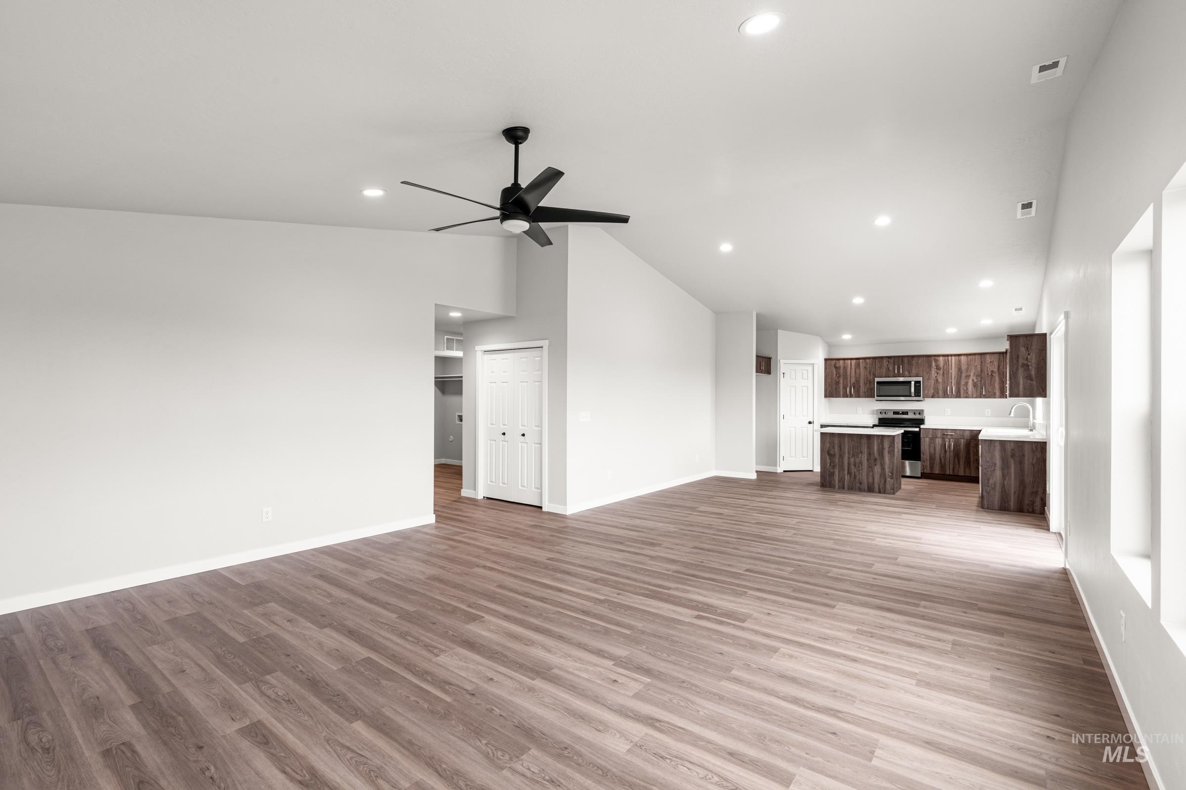 1449 Covington Street Middleton, ID 83644 - Photo 9 of 21 Unfurnished living room featuring lofted ceiling, a ceiling fan, light wood-type flooring, and recessed lighting