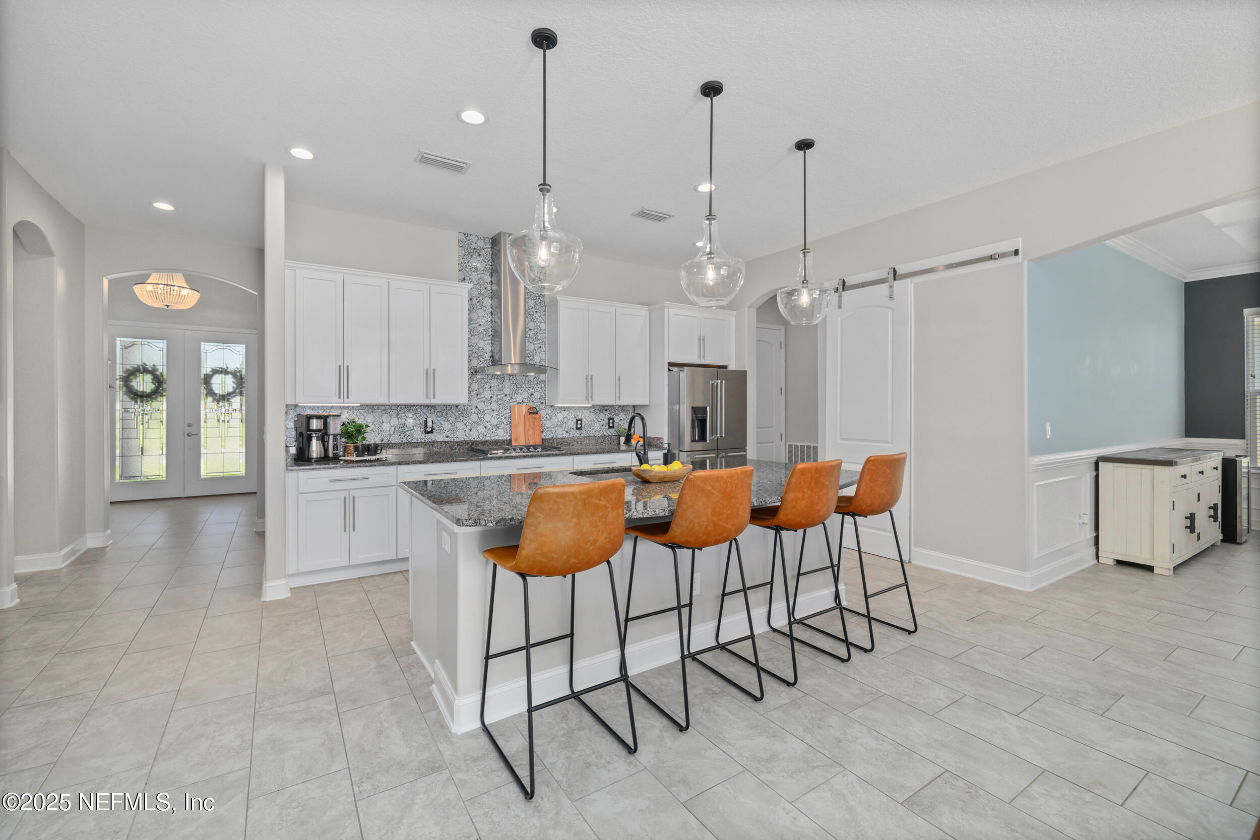 318 Windwalker Drive St. Augustine, FL 32092 - Photo 26 of 54 a large kitchen with kitchen island granite countertop lots of white cabinets appliances and a chandelier