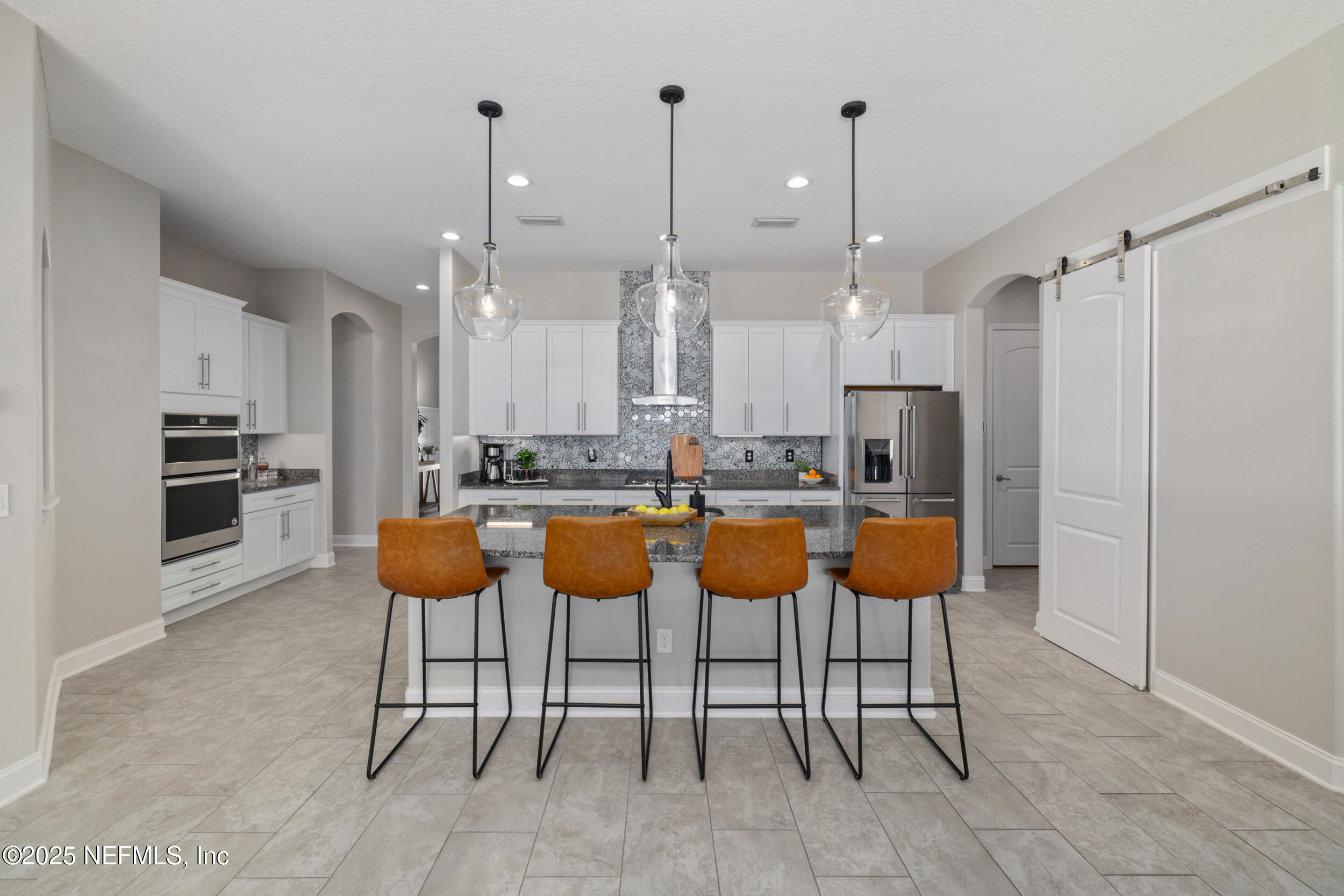 318 Windwalker Drive St. Augustine, FL 32092 - Photo 27 of 54 a kitchen with stainless steel appliances kitchen island granite countertop a table chairs and a refrigerator