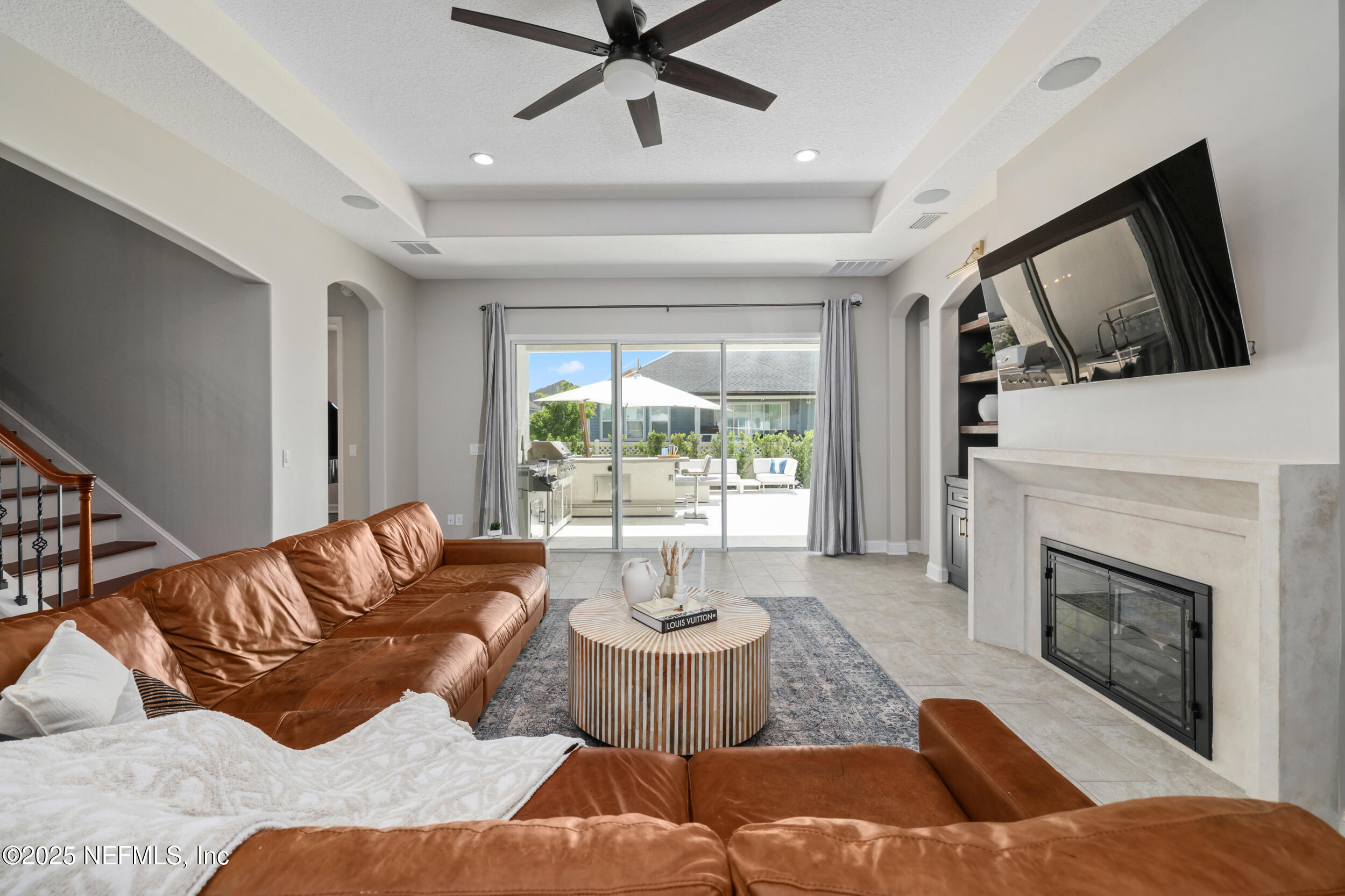 318 Windwalker Drive St. Augustine, FL 32092 - Photo 33 of 54 a living room with furniture a fireplace and a flat screen tv
