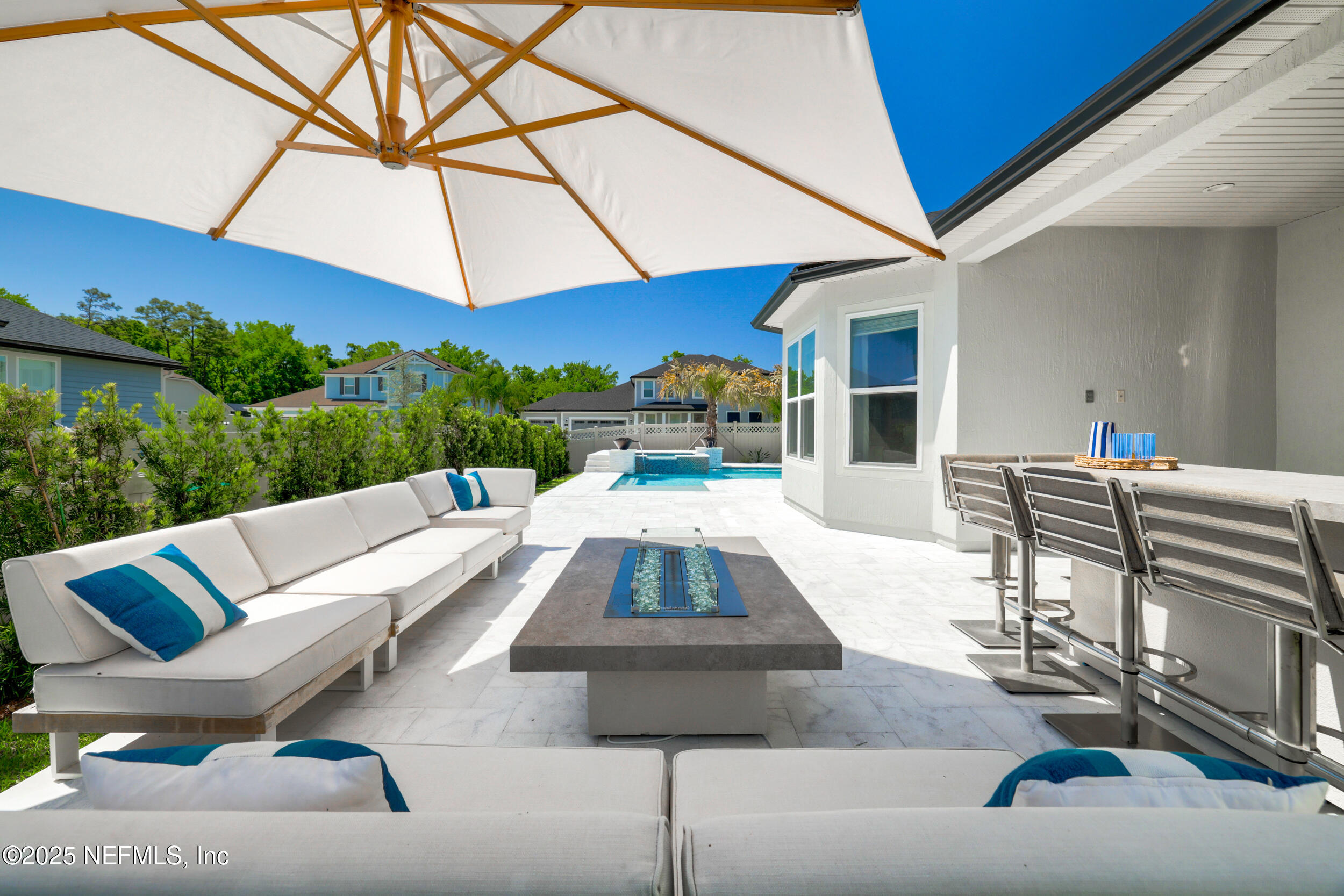 318 Windwalker Drive St. Augustine, FL 32092 - Photo 6 of 54 a view of a patio with a table and chairs under an umbrella