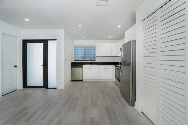 a kitchen with stainless steel appliances granite countertop a refrigerator and a sink