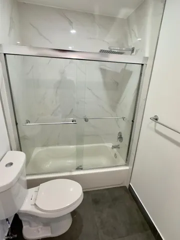 a bathroom with a toilet and a shower
