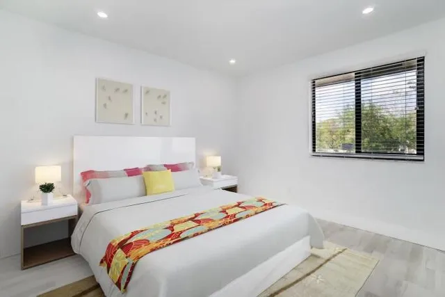 a bedroom with a bed and a painting on the wall