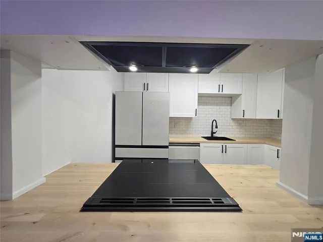 a large kitchen with stainless steel appliances granite countertop a sink counter space and cabinets