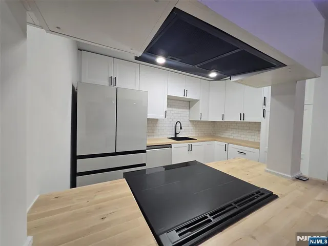 a kitchen with stainless steel appliances granite countertop a refrigerator and a stove top oven