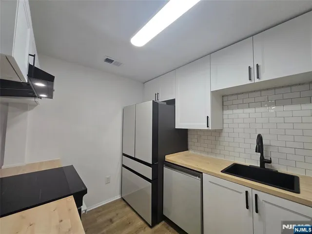 a kitchen with stainless steel appliances a sink and a refrigerator