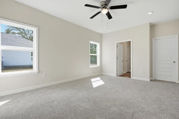 an empty room with closet and a ceiling fan