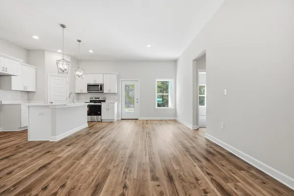 a view of a kitchen with wooden floor and electronic appliances