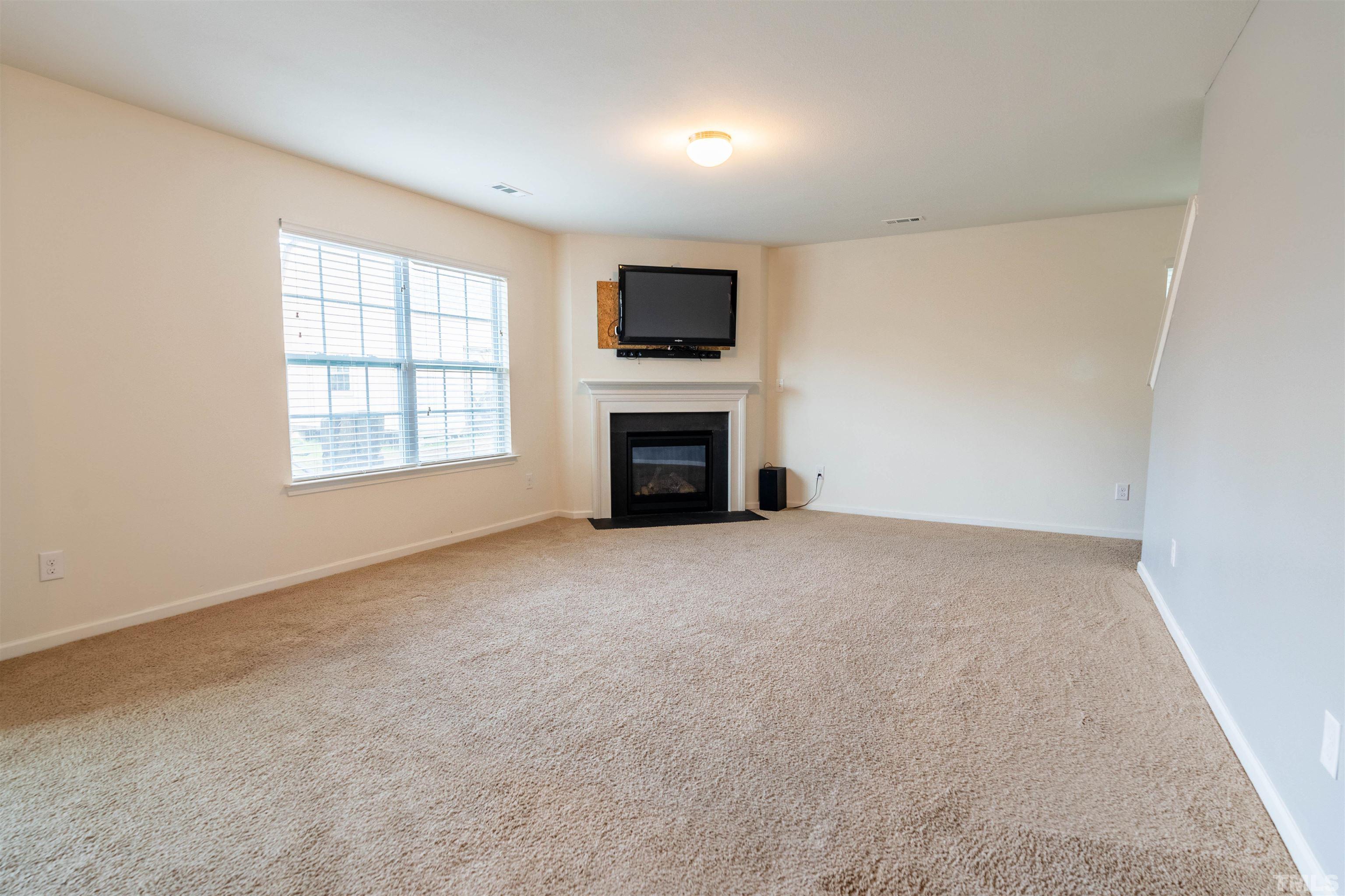 1848 Greenbrook Trail Dallas, NC 28034 - Photo 10 of 19 an empty room with a fireplace and a window