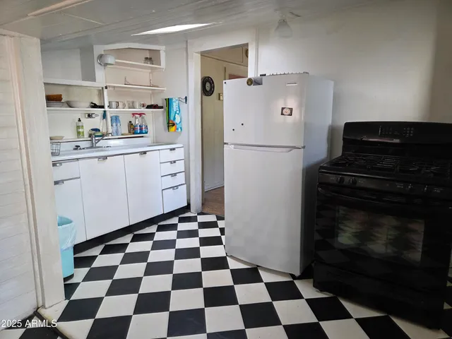 a kitchen with a checkered floor and white cabinets