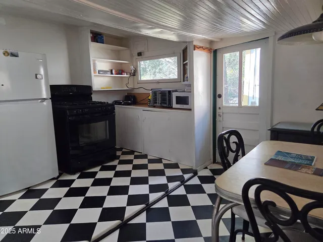 a kitchen with a checkered floor and white cabinets