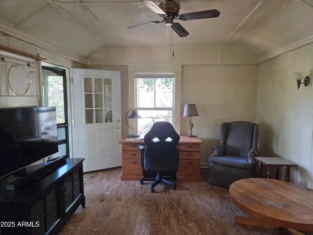 a living room with furniture a ceiling fan and a window