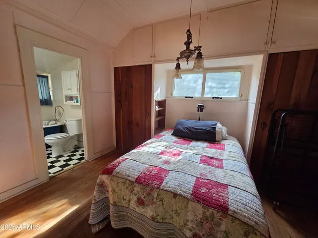 a bedroom with a bed and wooden floor