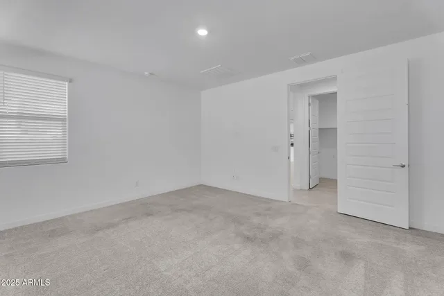 a kitchen with stainless steel appliances granite countertop a sink a stove a microwave a refrigerator and white cabinets