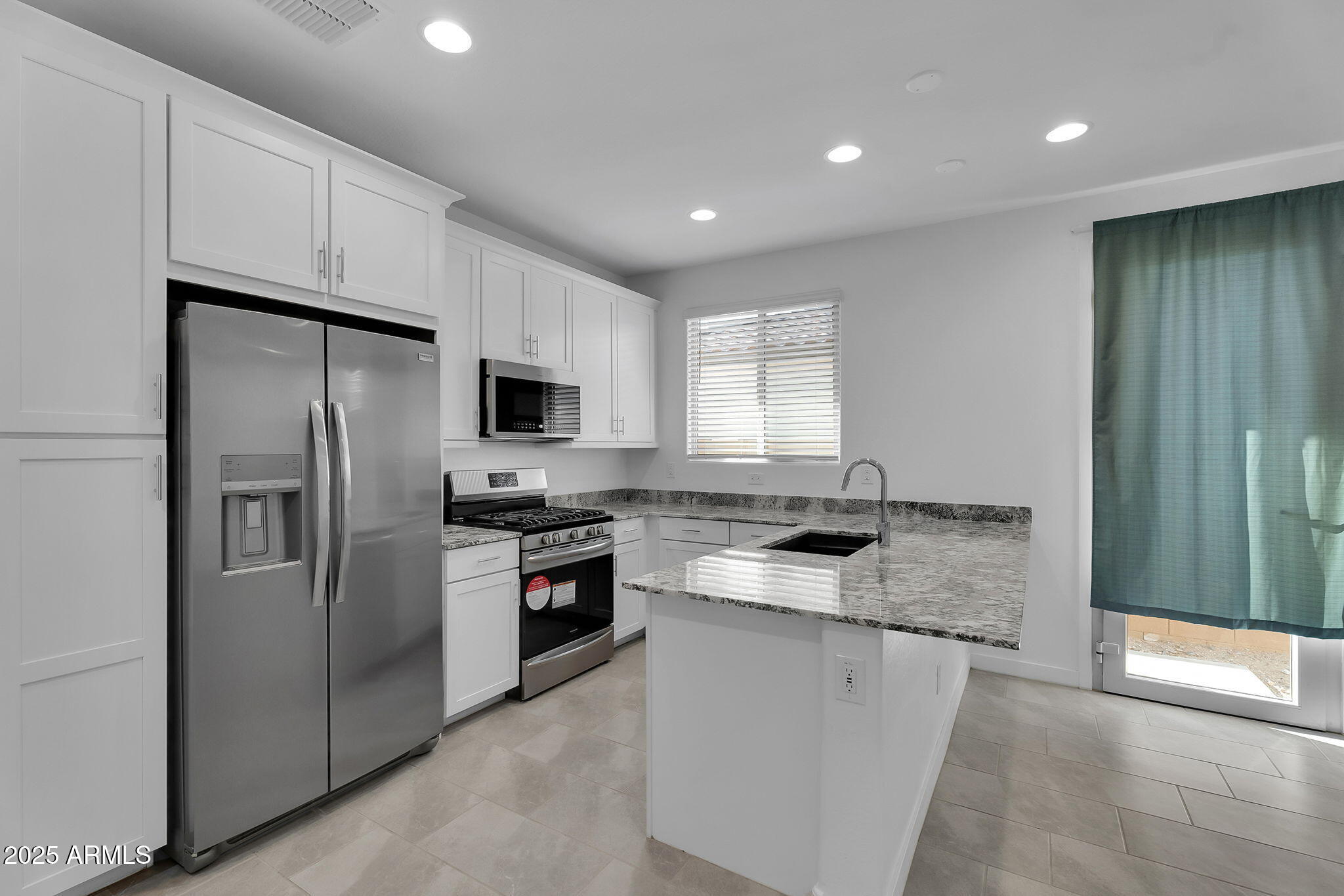 19948 West Flower Street Buckeye, AZ 85396 - Photo 17 of 58 a kitchen with stainless steel appliances granite countertop a refrigerator a sink and a stove