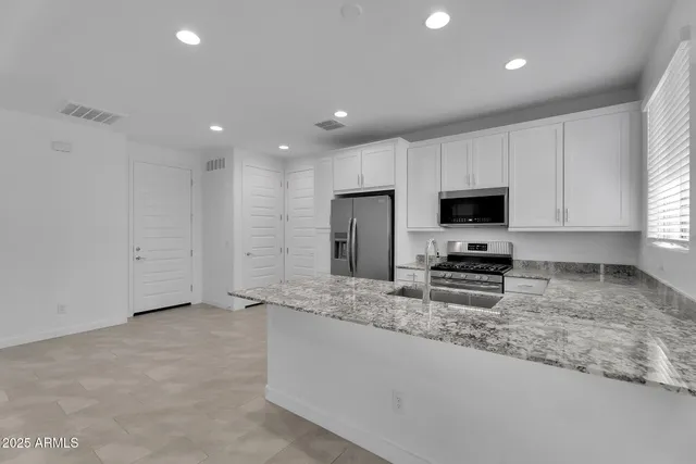 a kitchen with stainless steel appliances granite countertop a sink and a stove