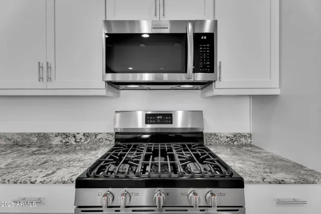 a large kitchen with stainless steel appliances a large counter top and oven