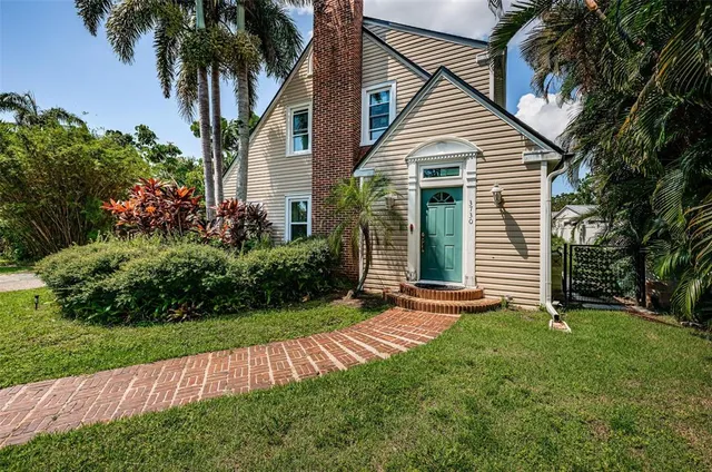 a front view of a house with a yard and potted plants