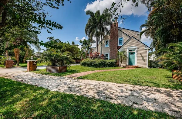 a front view of a house with a yard and potted plants