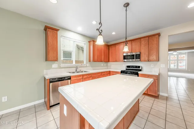 a kitchen with stainless steel appliances granite countertop a sink a stove and a refrigerator