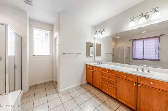 a spacious bathroom with a mirror sink and shower