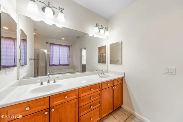 a bathroom with a granite countertop double vanity sink and mirror